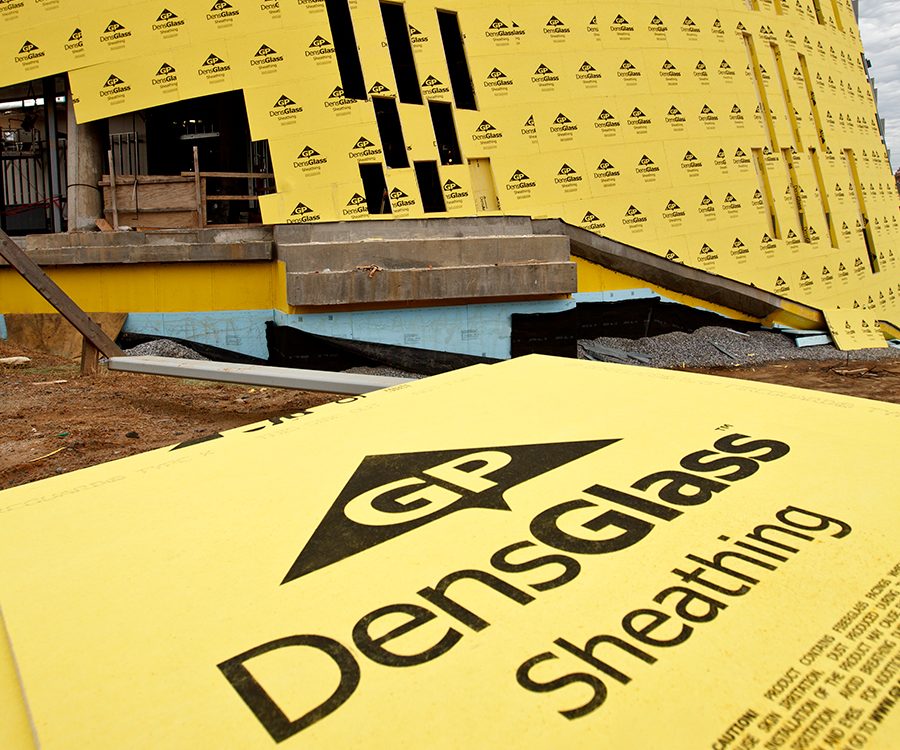 Close-up view of DensGlass Sheathing installed as a shaftliner in the framing of a multi-family building, showcasing its durable, moisture-resistant gypsum core and fiberglass mat exterior designed for fire-rated assemblies.